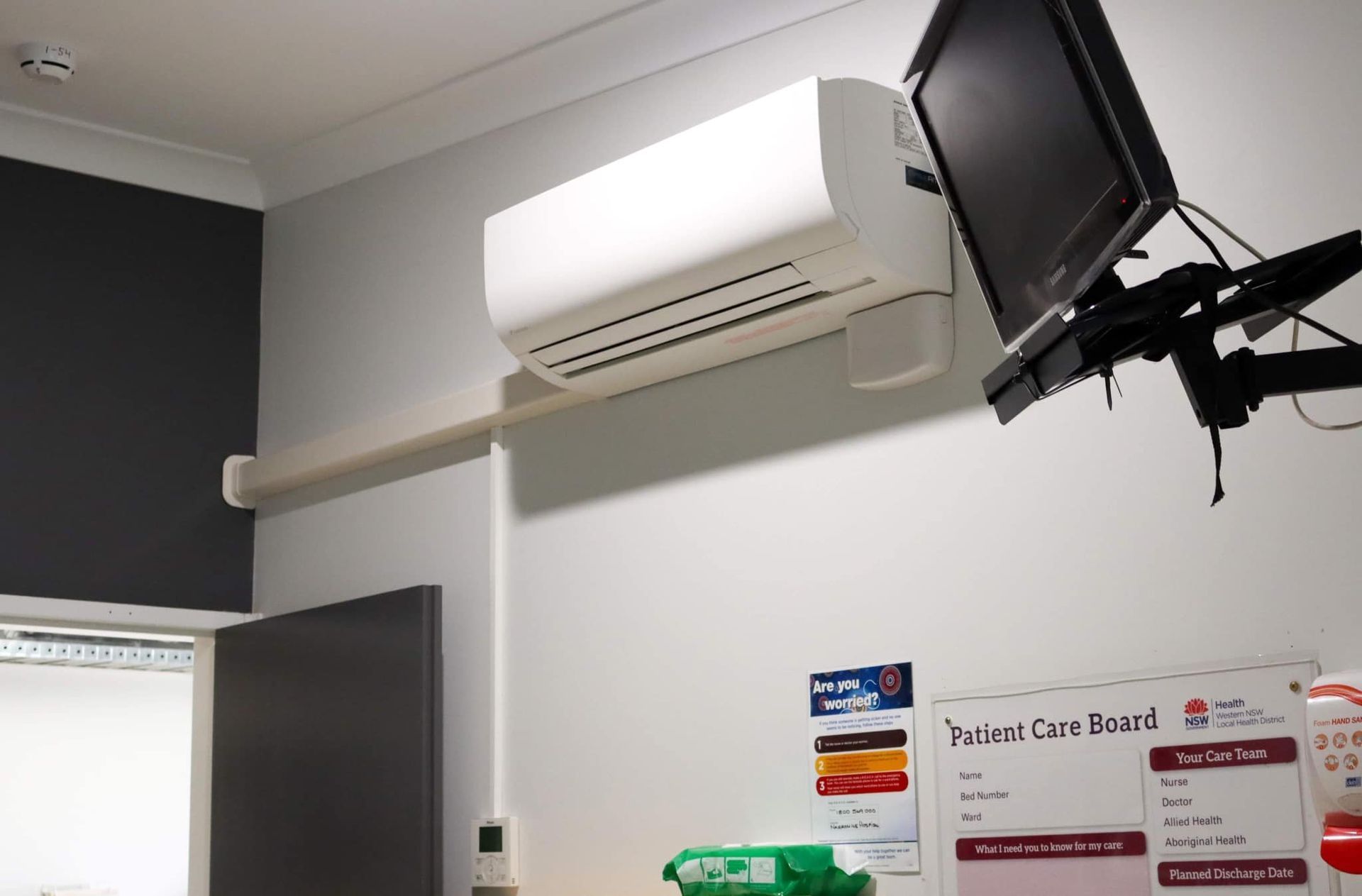 Wall-mounted split system air conditioner installed in a hospital patient room.