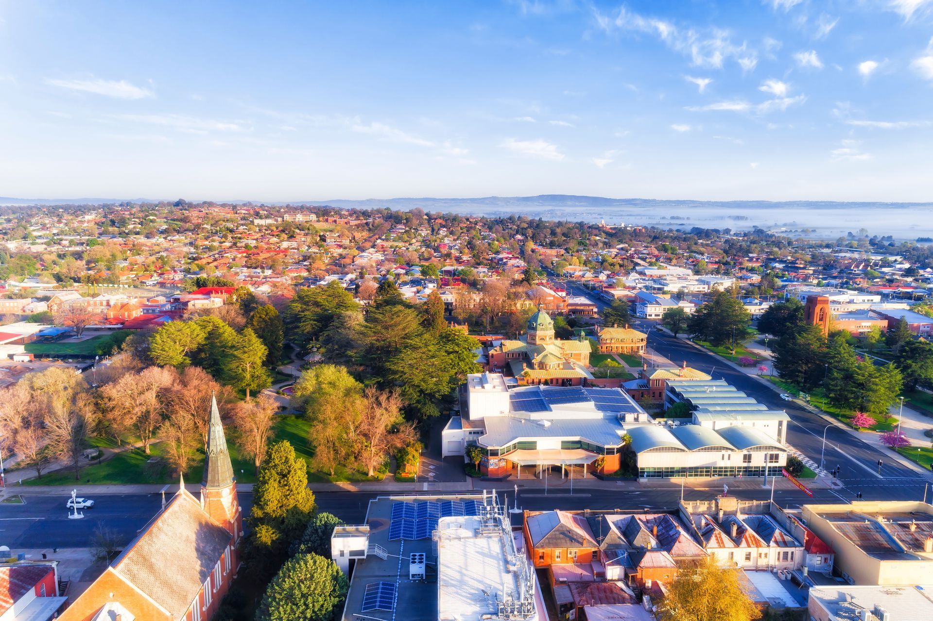 Aerial view of a town with buildings, trees, and road under a blue sky— Chill-Rite Refrigeration and Air Conditioning in Newcastle, NSW