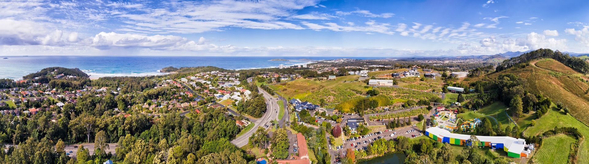 Panoramic view of a coastal town, with houses, trees, and ocean under a blue sky— Chill-Rite Refrigeration and Air Conditioning in Newcastle, NSW