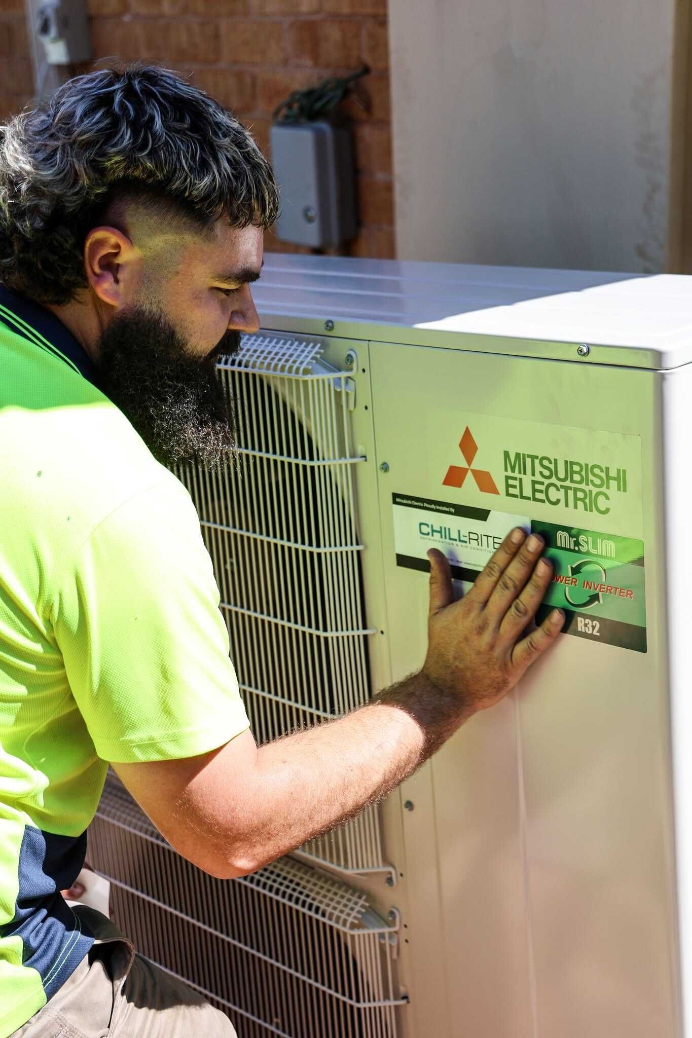 Technician Inspecting Outdoor Mitsubishi Air Conditioning In Tamworth — Chill-Rite Refrigeration and Air Conditioning in Tamworth, NSW