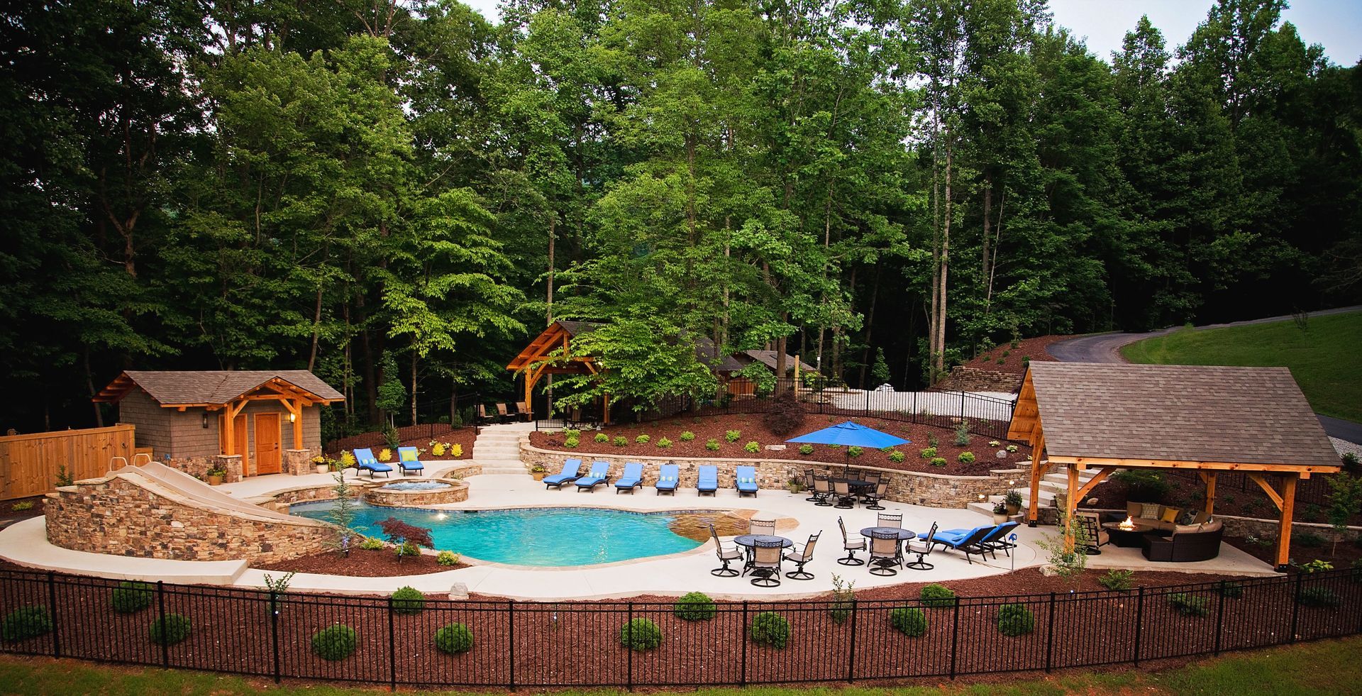 An aerial view of a large swimming pool surrounded by trees.