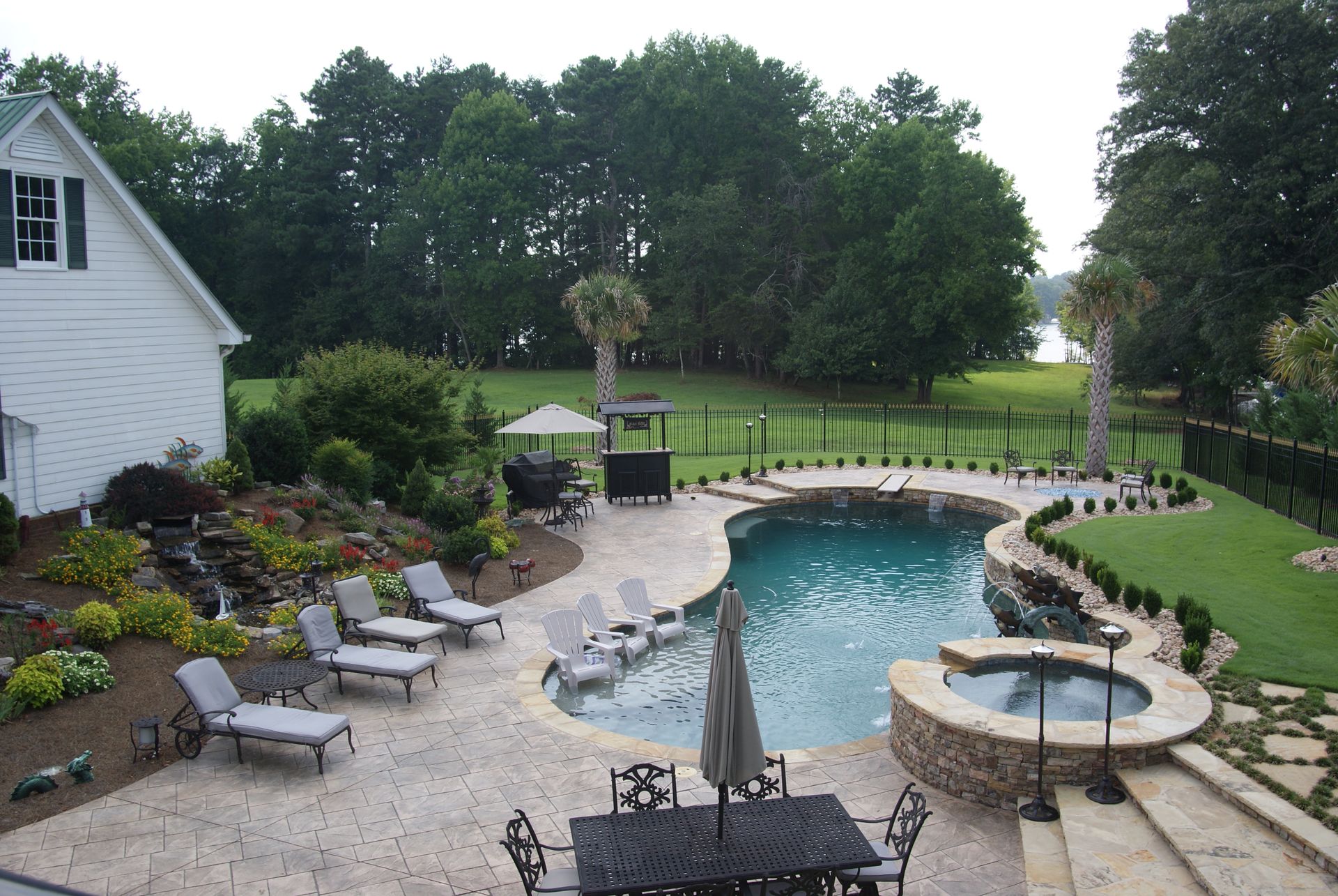A large swimming pool with a table and chairs around it