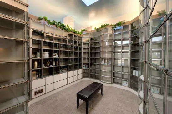 Spacious modern library with curved bookshelves, glass walls, and a bench in the center