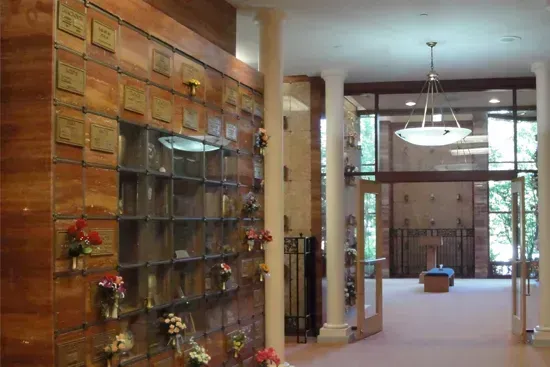 Modern lobby with a brick wall display, glass shelves, and a bright seating area beyond.