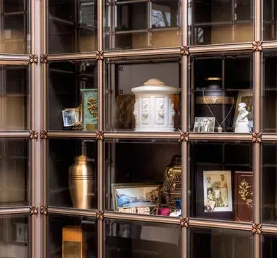Decorative display shelves with framed photos, vases, and ornaments in warm brown tones