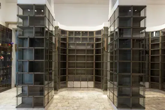 Empty modern room with tall dark metal shelving units and a tiled floor