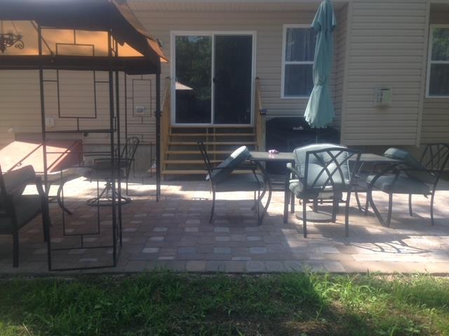 Patio with outdoor furniture, a gazebo, and a sliding glass door.