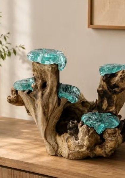 Statuine che si baciano sulla torta nuziale, accanto a uno sfondo floreale esagonale e nastri verdi sul tavolo dei dolci.