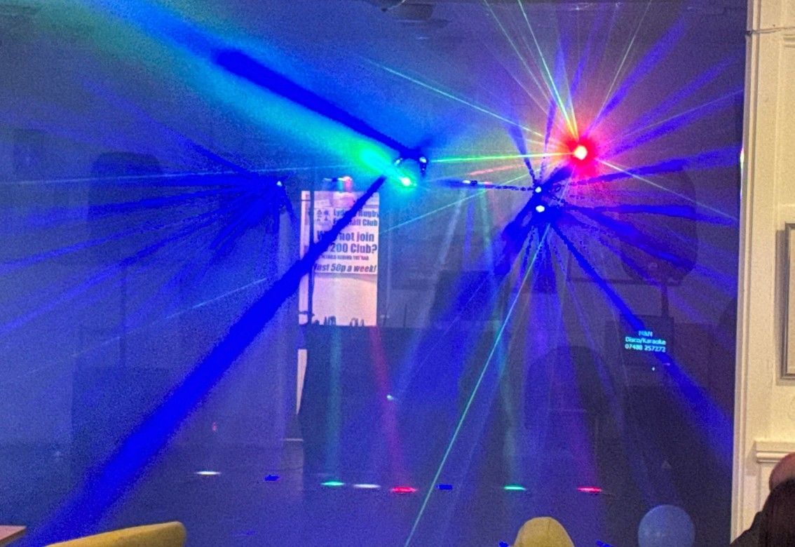 Blue and red stage lights and laser beams in a dark indoor room