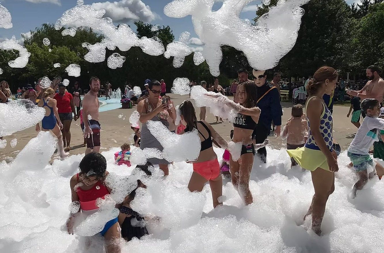 Children playing in a foam-filled outdoor area at a summer event