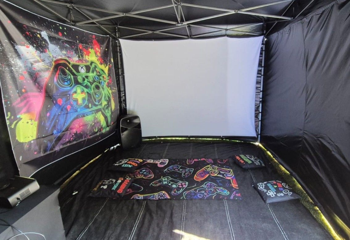 Colorful canopy tent interior with neon graffiti-style bedding and a white screen at the back