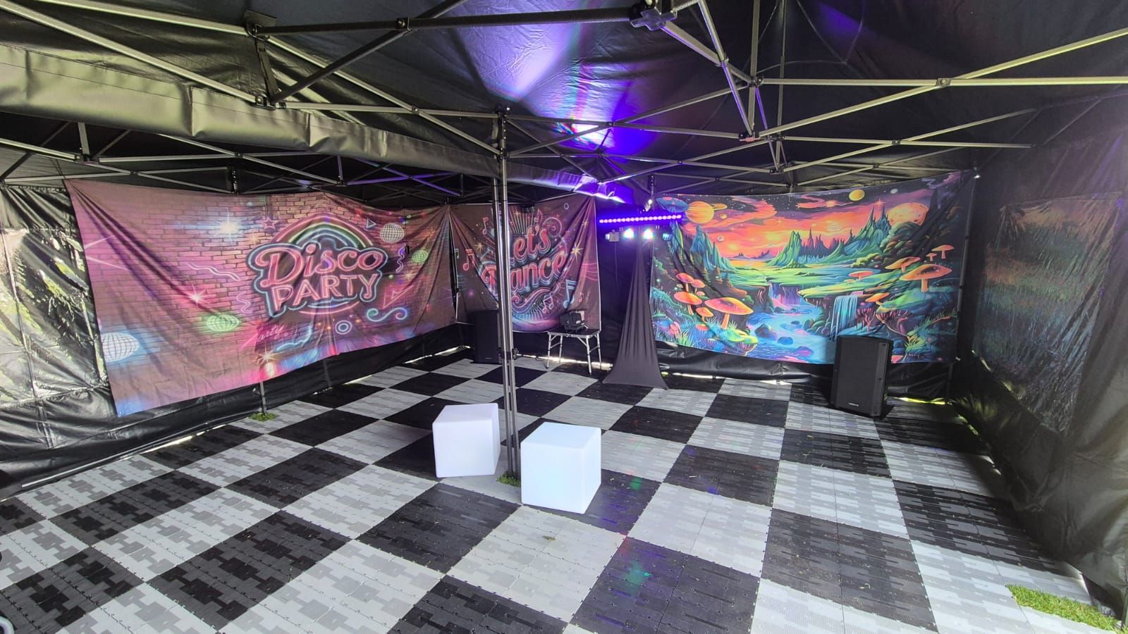 Purple-lit room with a checkered floor and a large mural of a DJ on the back wall