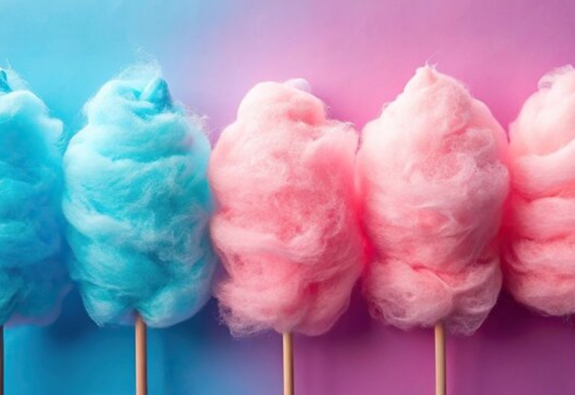 Four pastel cotton candy puffs on sticks in blue and pink against a pink-blue background