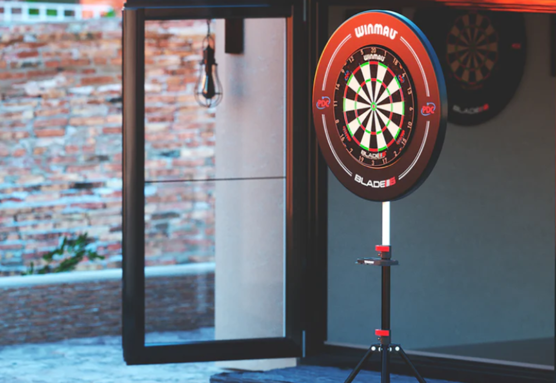 Red dartboard on a stand in a modern indoor room near a glass door