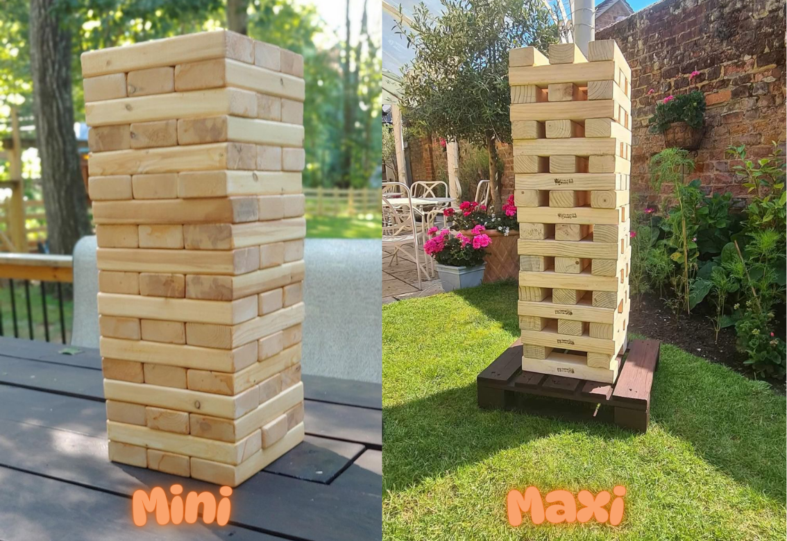 Two tall wooden block towers labeled Mini and Maxi outdoors in a garden.