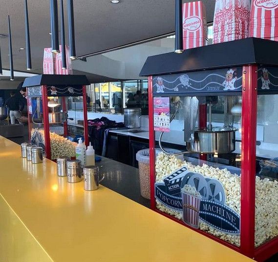 Popcorn and snack stand with red-and-black counters in a movie theater lobby