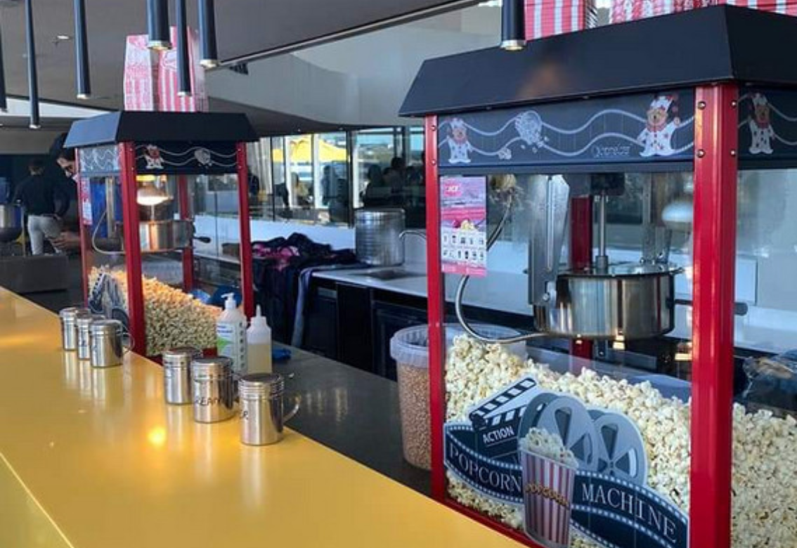 Empty restaurant counter with red frames, condiment jars, and a hot food station behind glass.