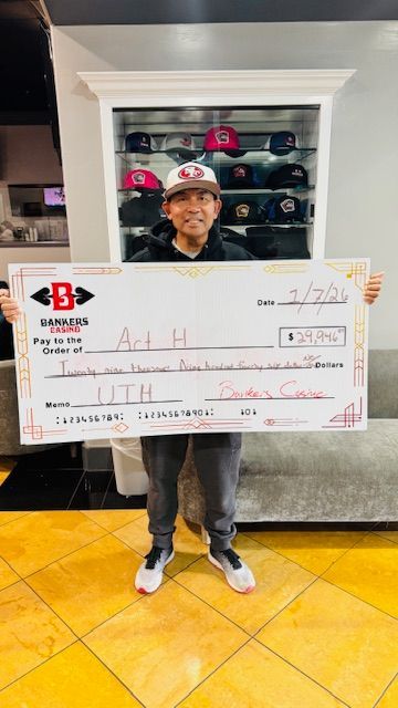 Person holding an oversized check in a sneaker shop, standing in front of a wall of shoes.