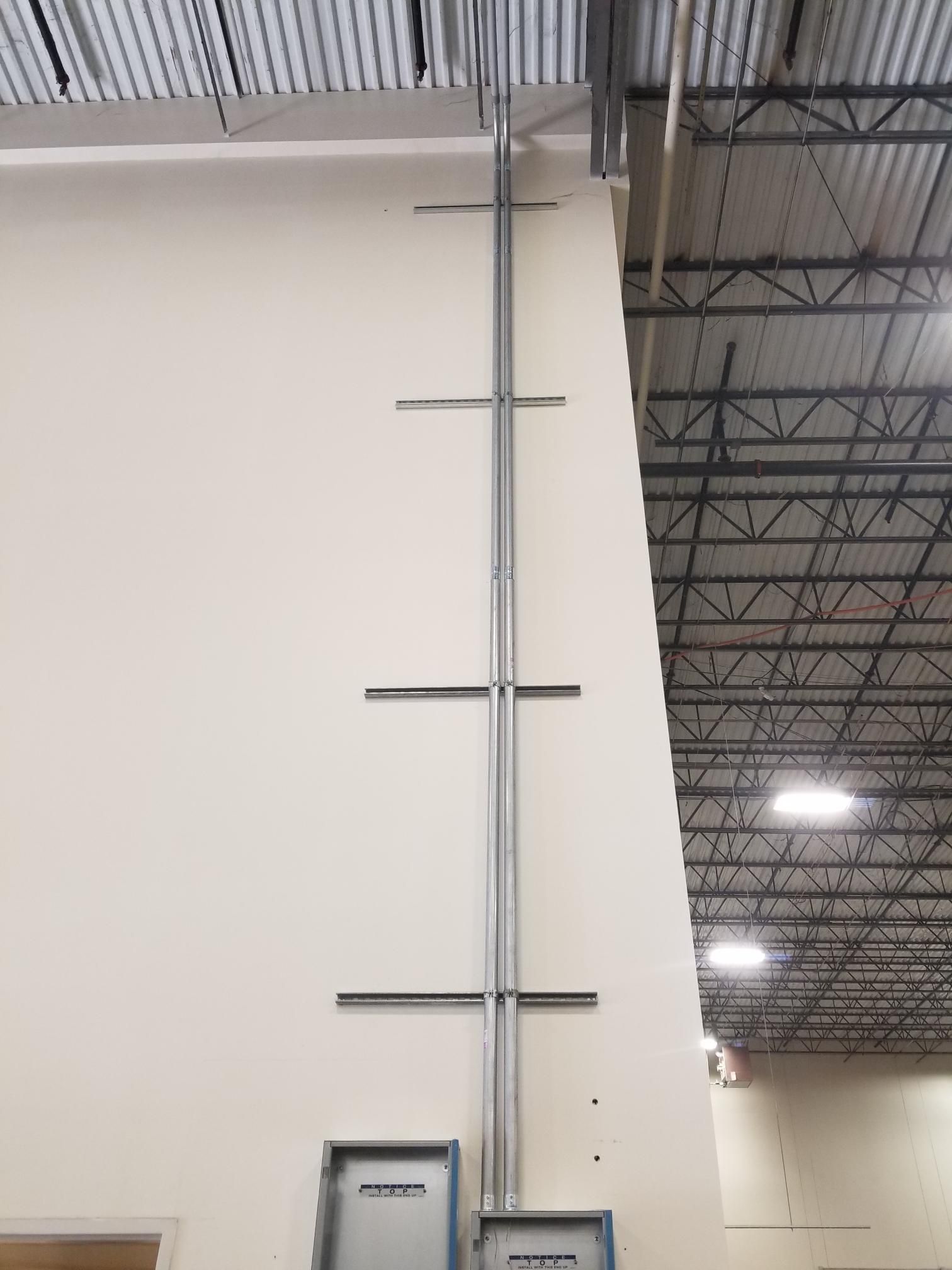 Tall metal ladder beside a white wall in a warehouse interior