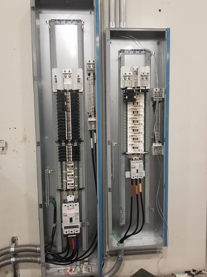 Electrical panel with wiring and components inside metal enclosure mounted on a wall.