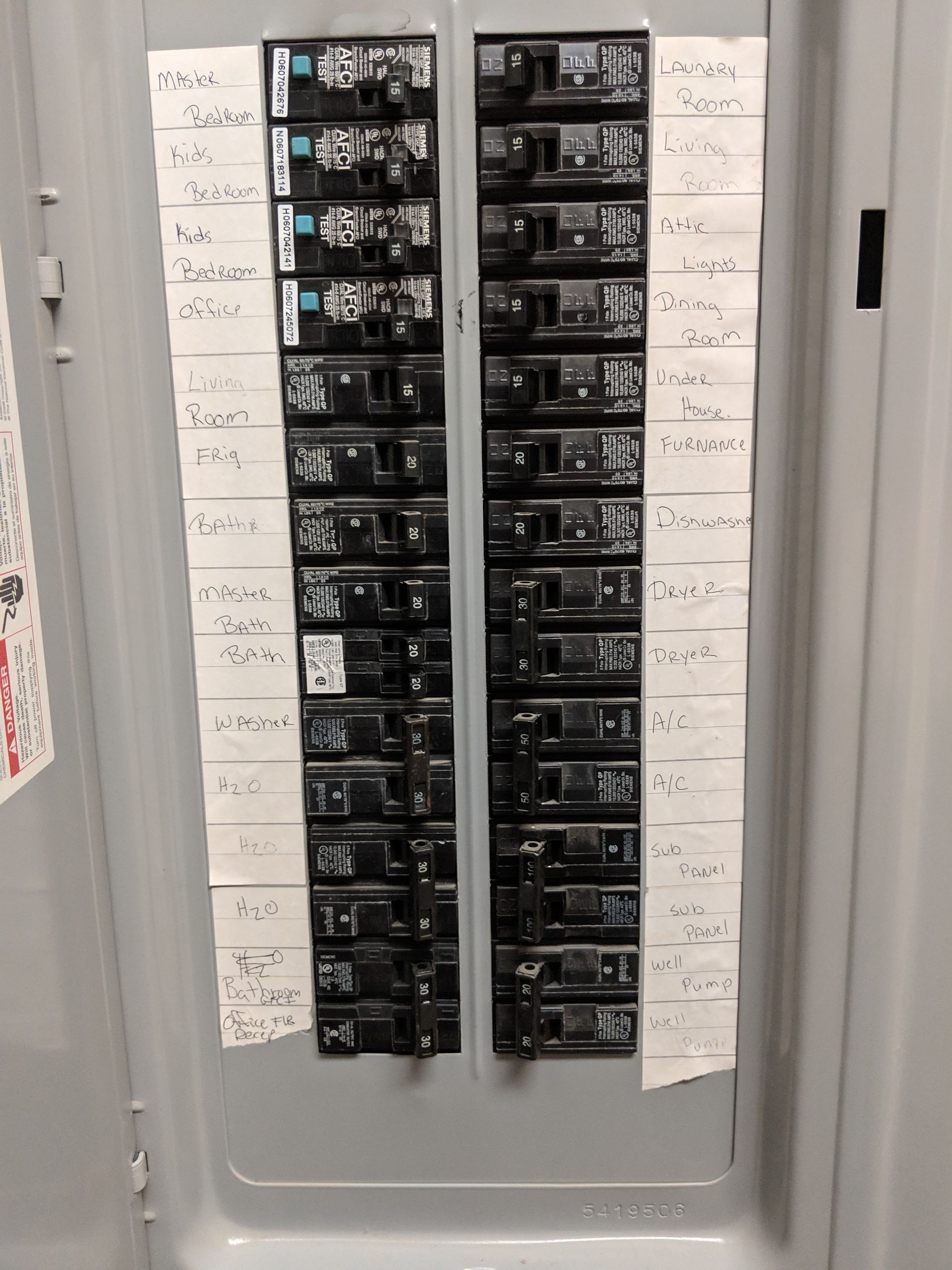 Electrical circuit breaker panel with labels identifying circuits.