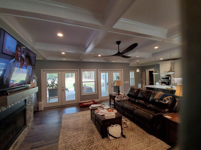 Modern living room with fireplace, TV, sectional sofa, coffee table, and French doors to a patio