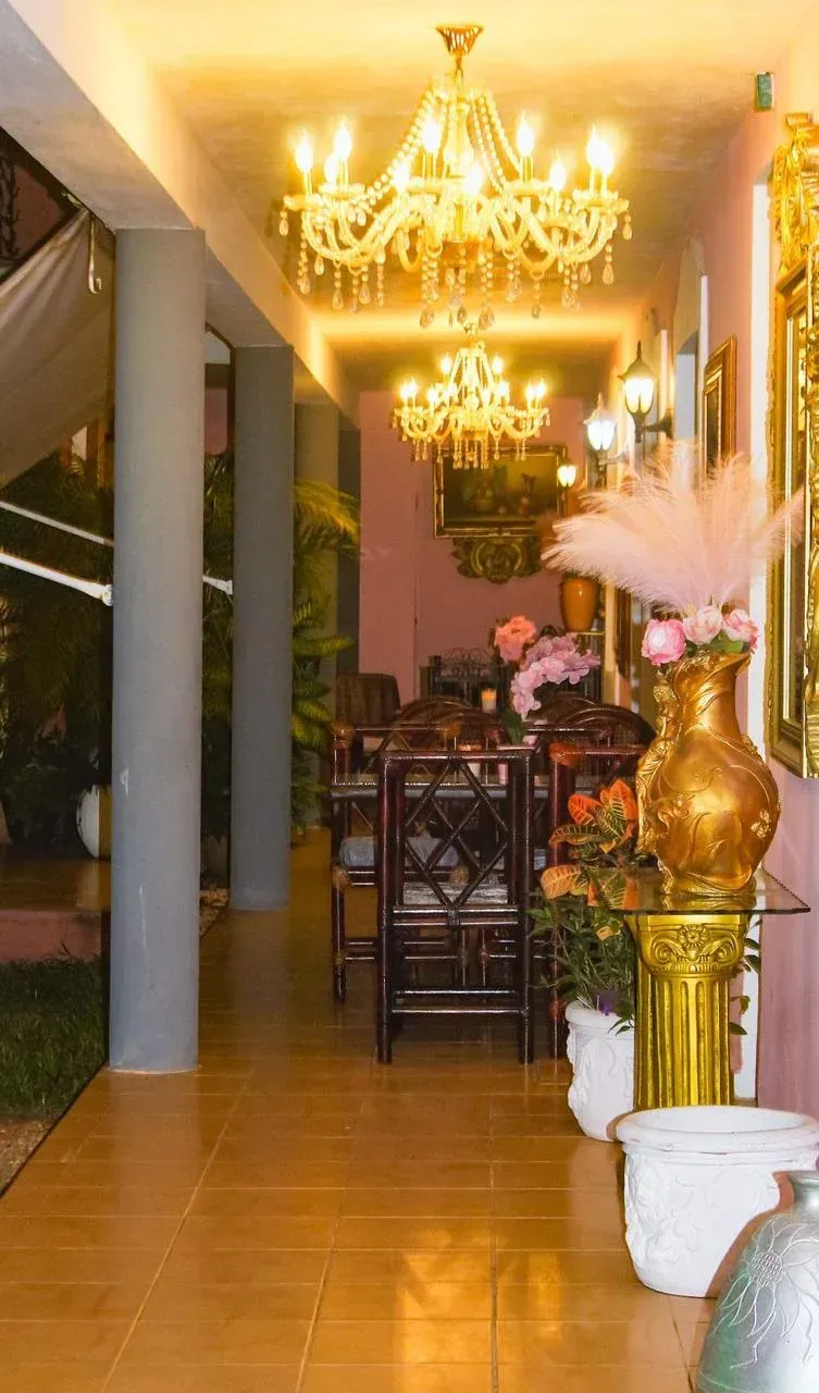 Elegant dining area with chandeliers, ornate furniture, and floral arrangements.