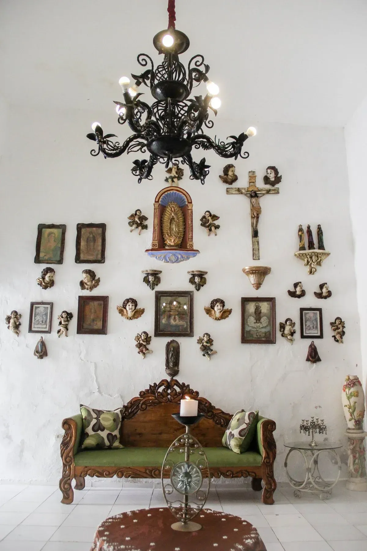 Ornate living room with antique furniture, religious art, and chandelier.