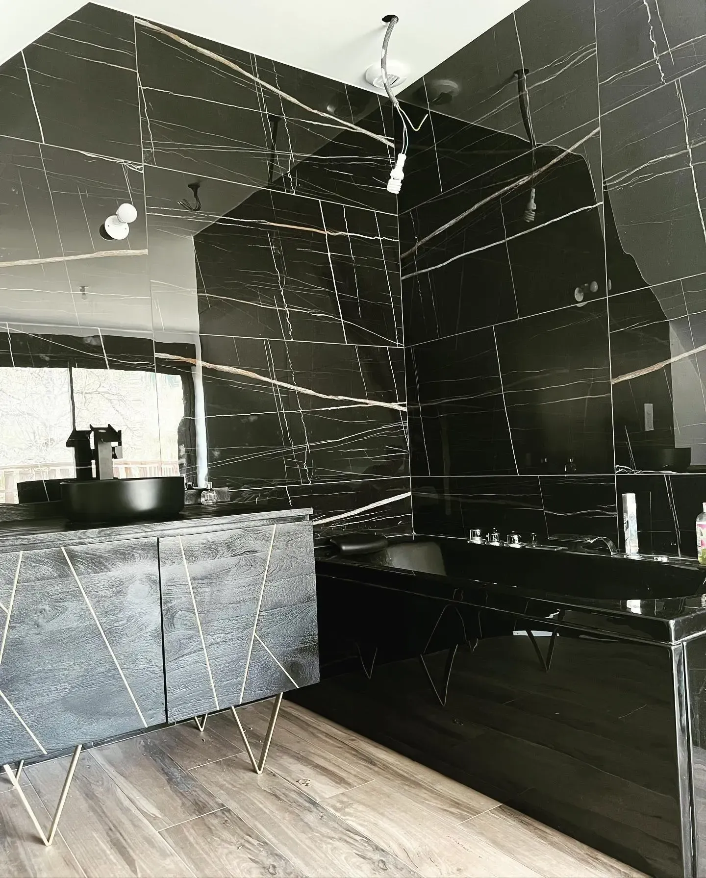 une salle de bain avec carrelage noir et lavabo
