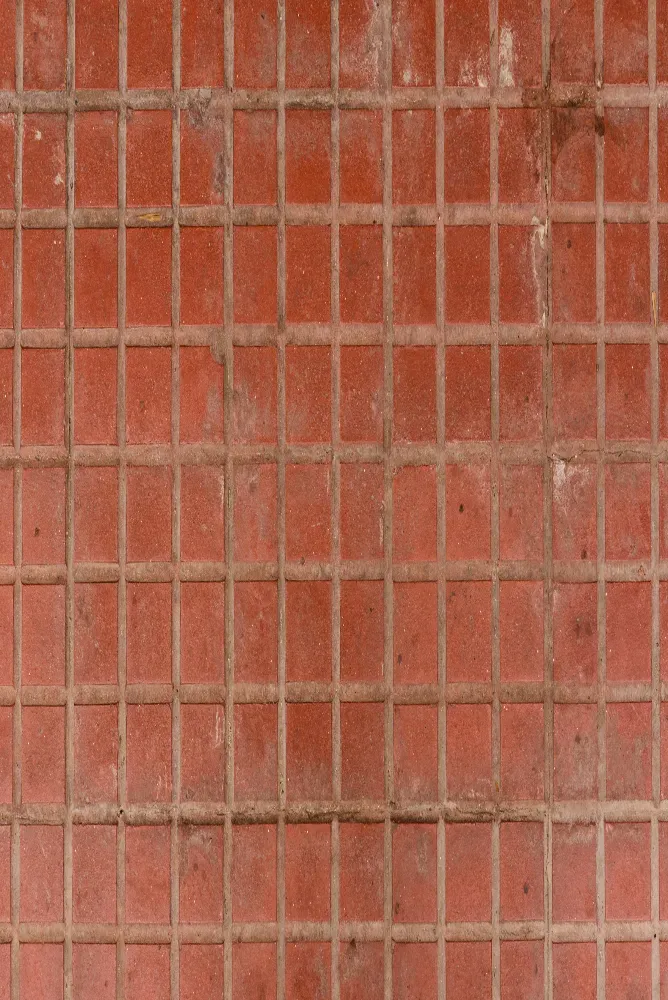 un gros plan d'un sol carrelé rouge avec un motif en grille.