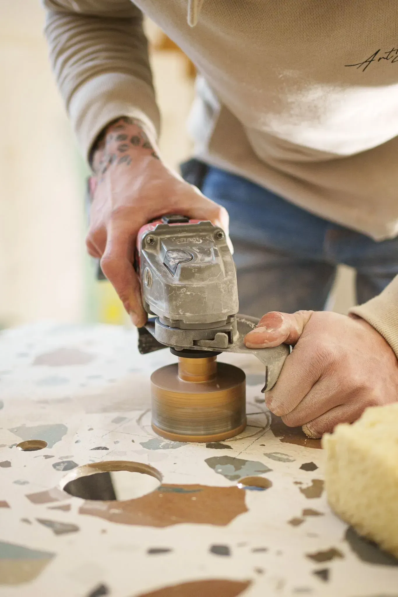 une personne travaille sur une table avec une perceuse .