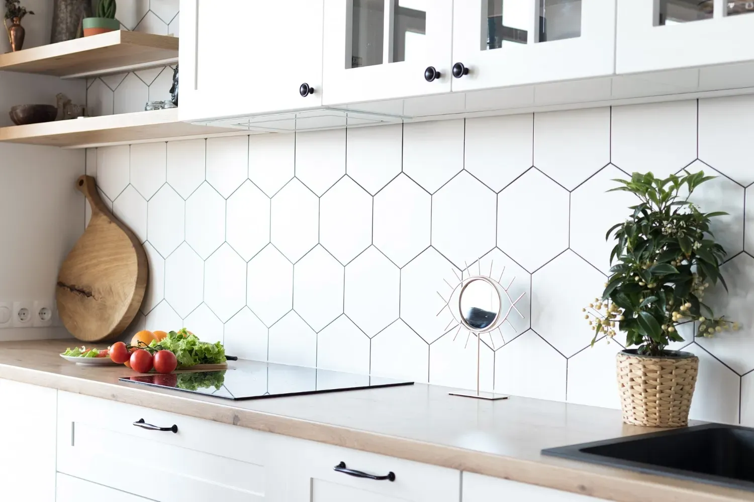 une cuisine avec des armoires blanches et des carreaux hexagonaux