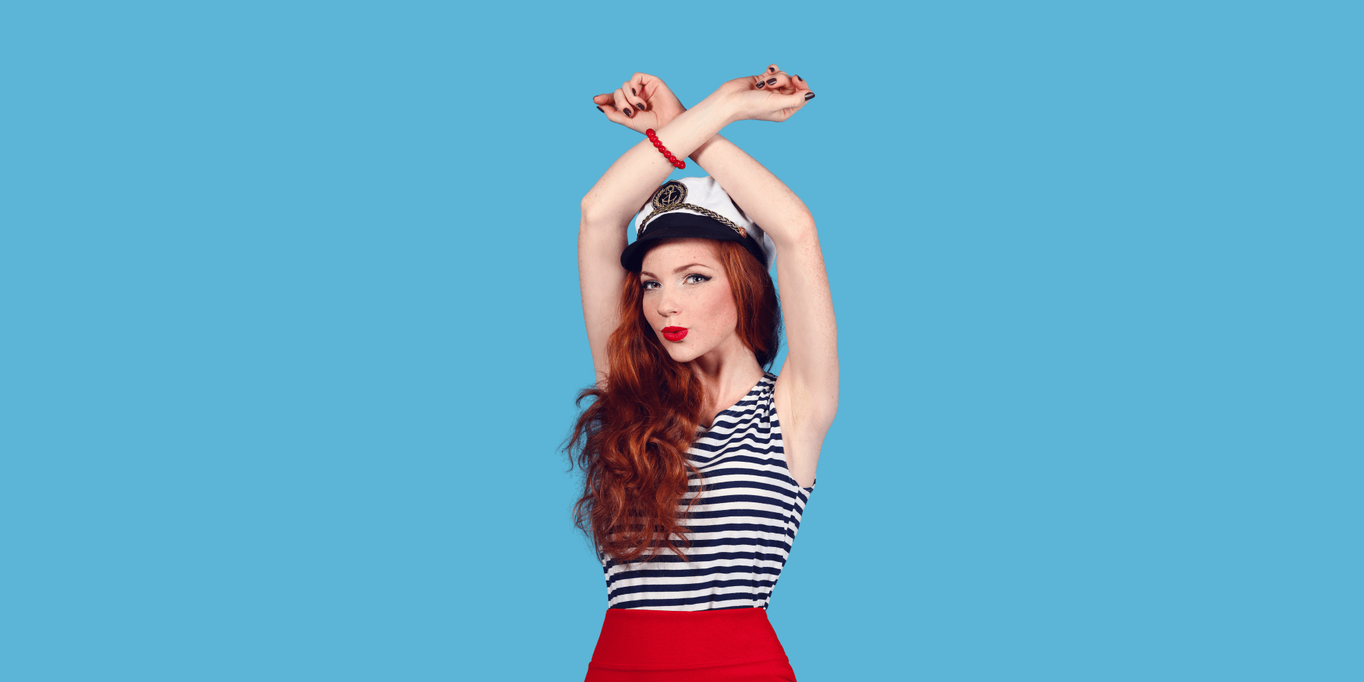 The woman is wearing a sailor hat and a striped shirt.