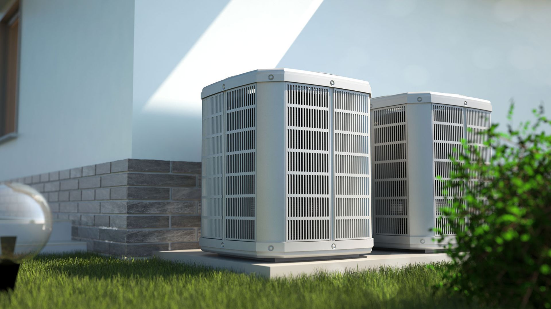Two air conditioning units next to a house, on a grassy lawn.