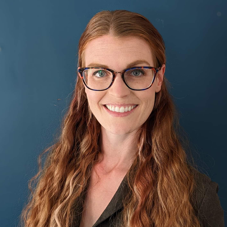 The woman is wearing glasses and smiling for the camera.