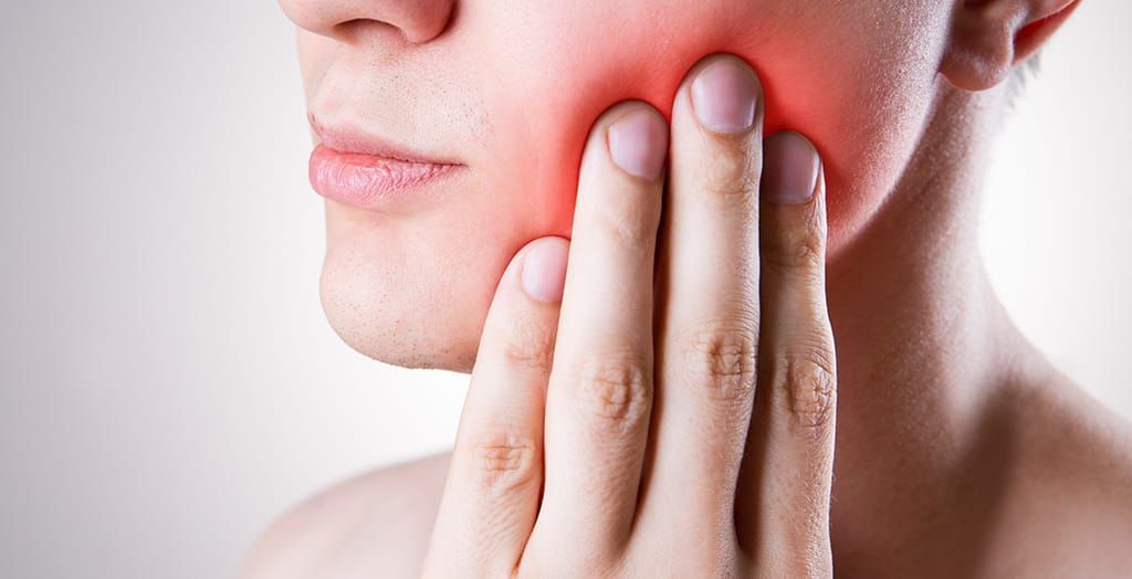A woman is holding her mouth in pain because of a toothache. A woman is holding her mouth in pain because of a toothache.