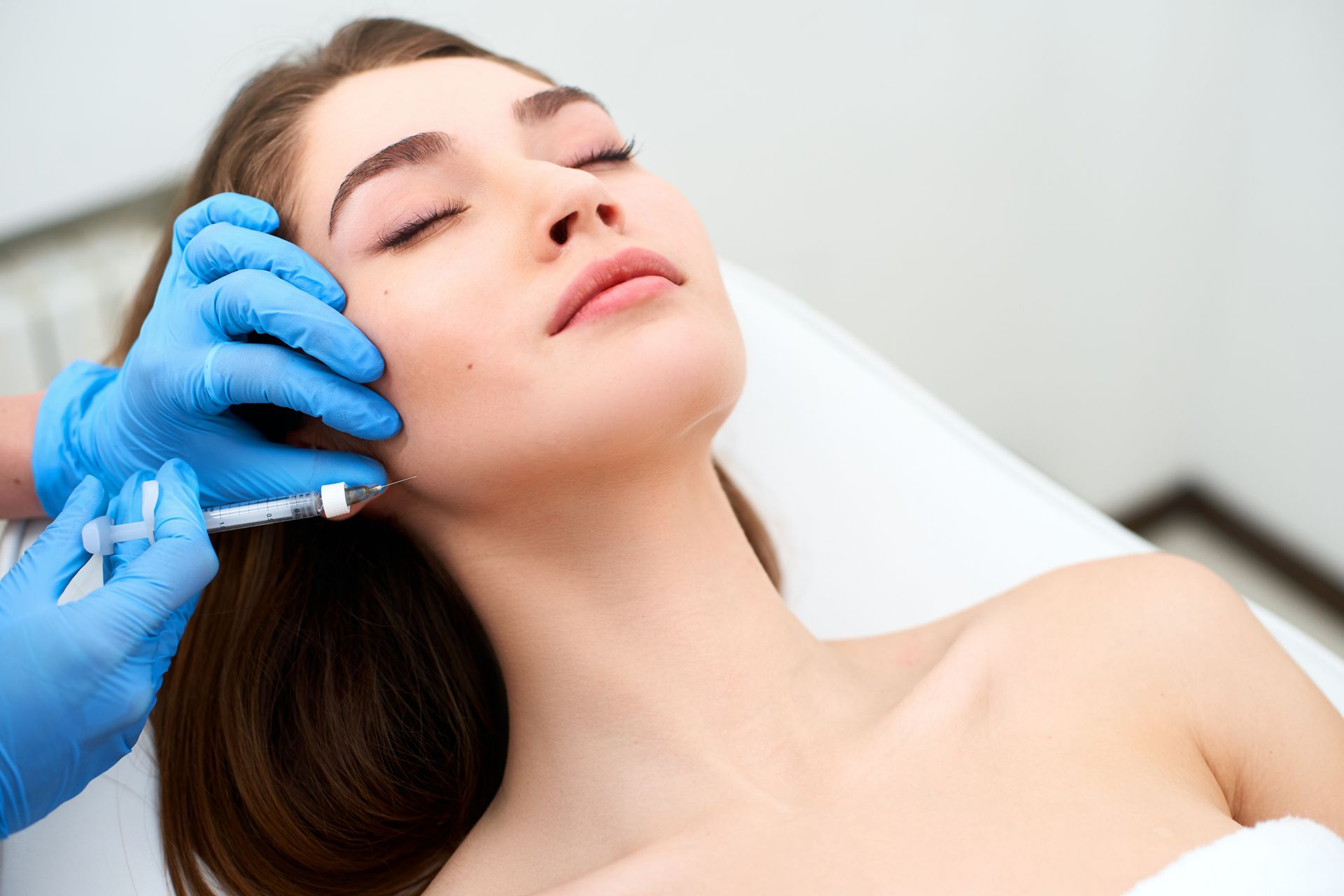 A man with a beard is getting a botox injection in his face. A man with a beard is getting a botox injection in his face.