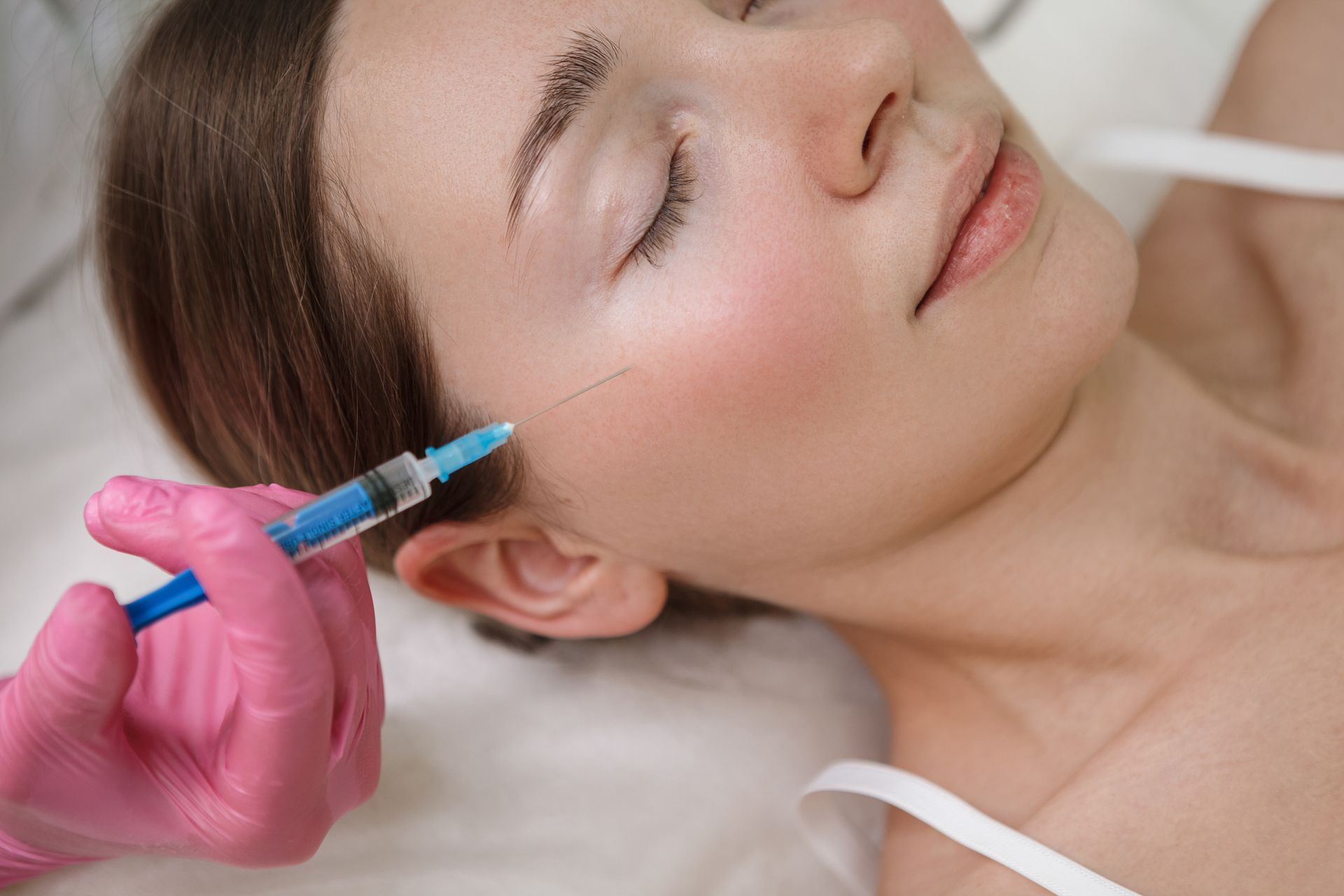 A man with a beard is getting a botox injection in his face. A man with a beard is getting a botox injection in his face.