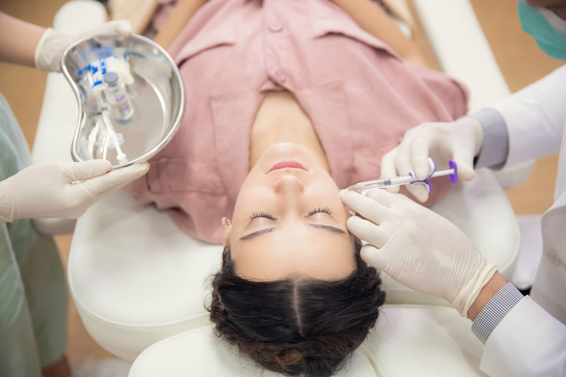 A man with a beard is getting a botox injection in his face. A man with a beard is getting a botox injection in his face.