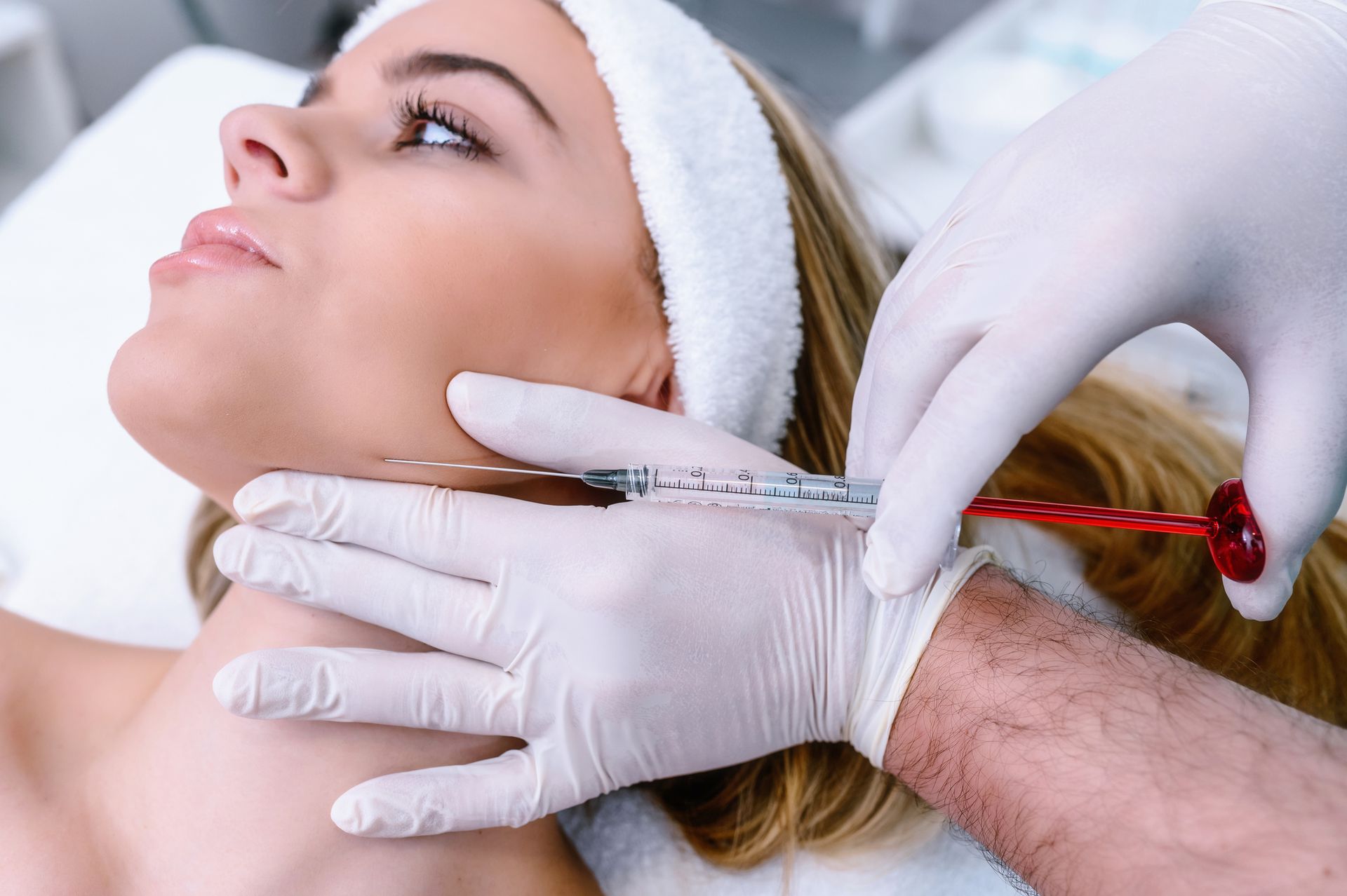 A man with a beard is getting a botox injection in his face. A man with a beard is getting a botox injection in his face.