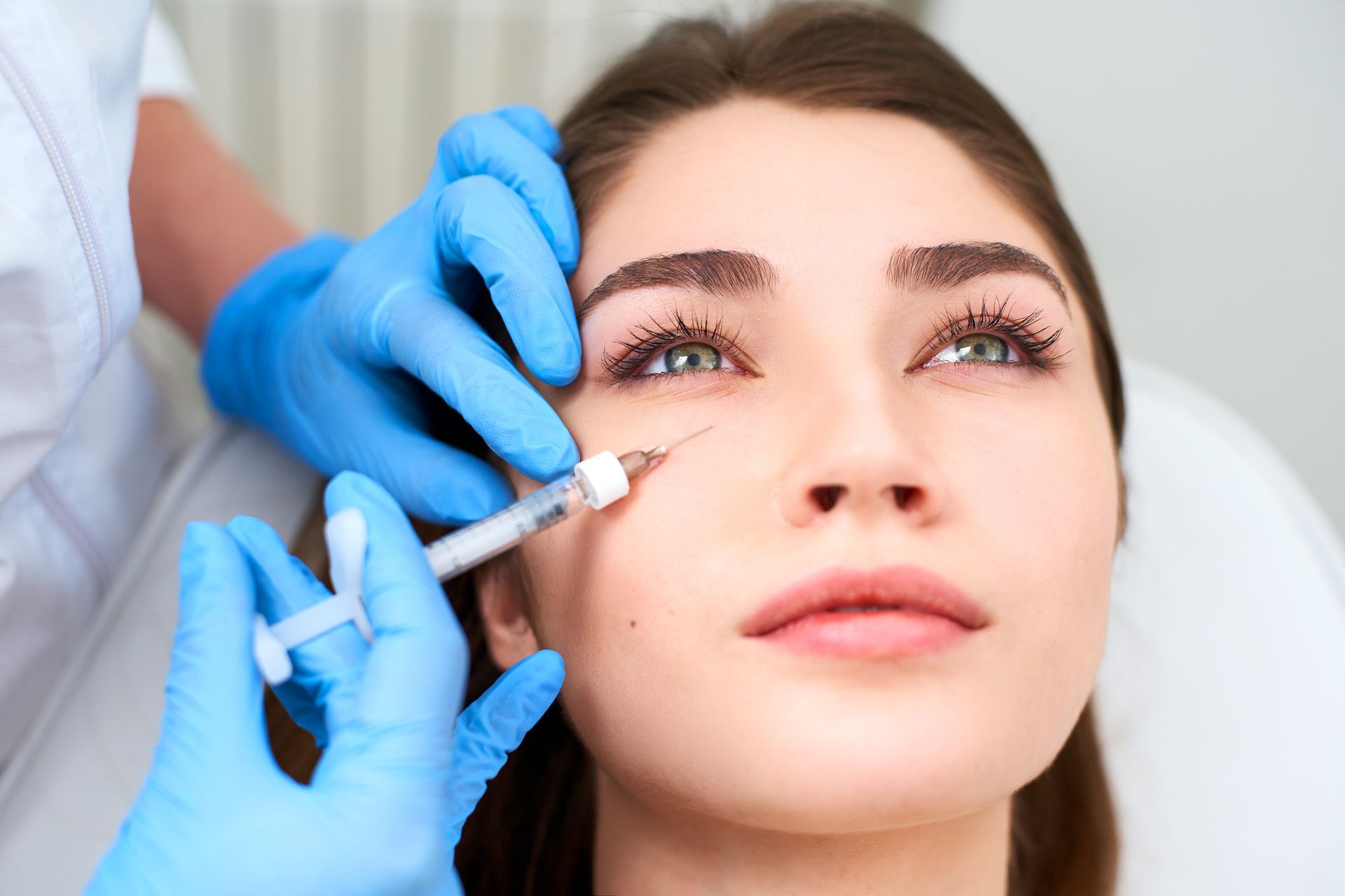 A man with a beard is getting a botox injection in his face. A man with a beard is getting a botox injection in his face.