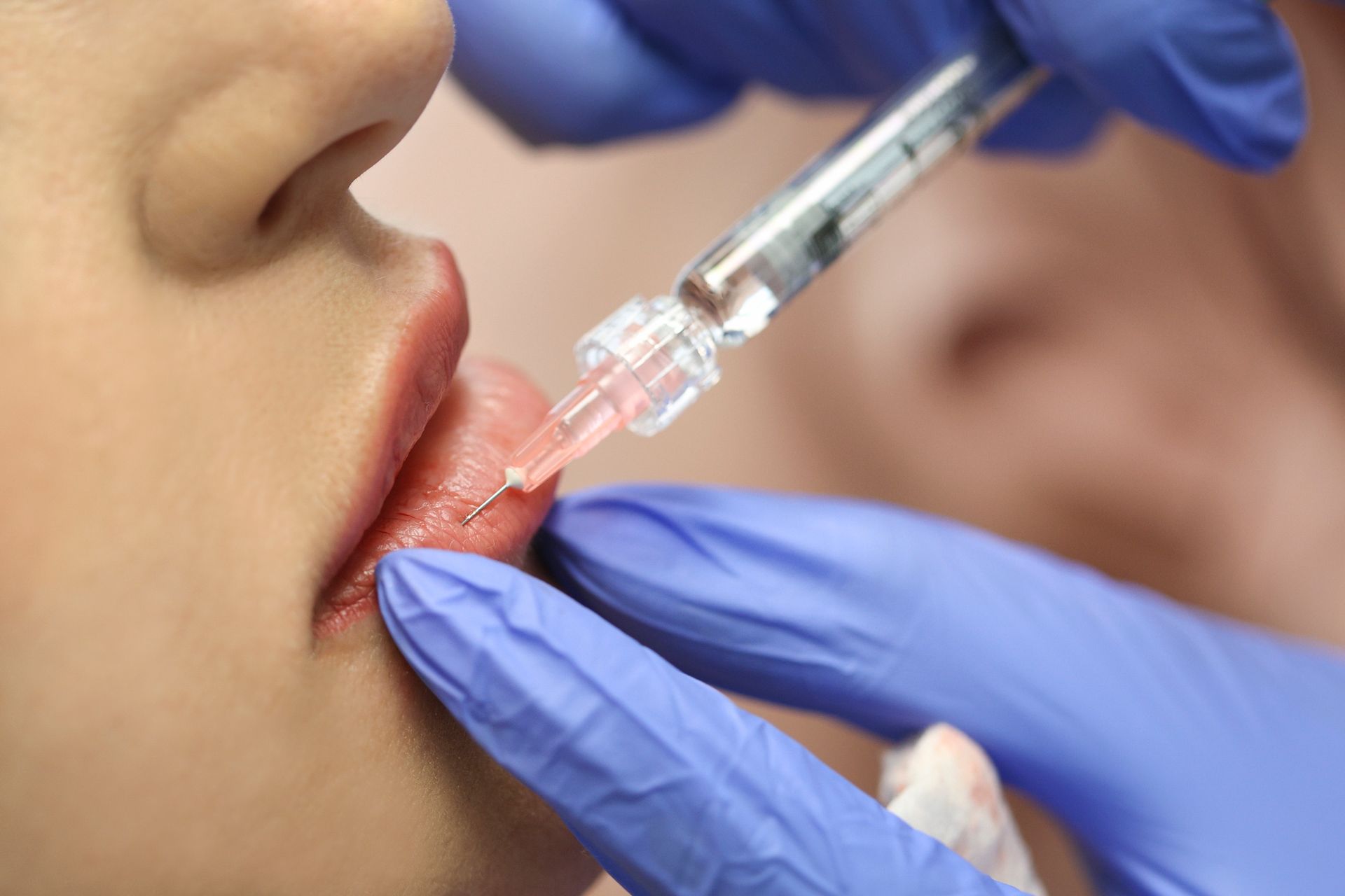 A woman is getting a botox injection in her lips. A woman is getting a botox injection in her lips.