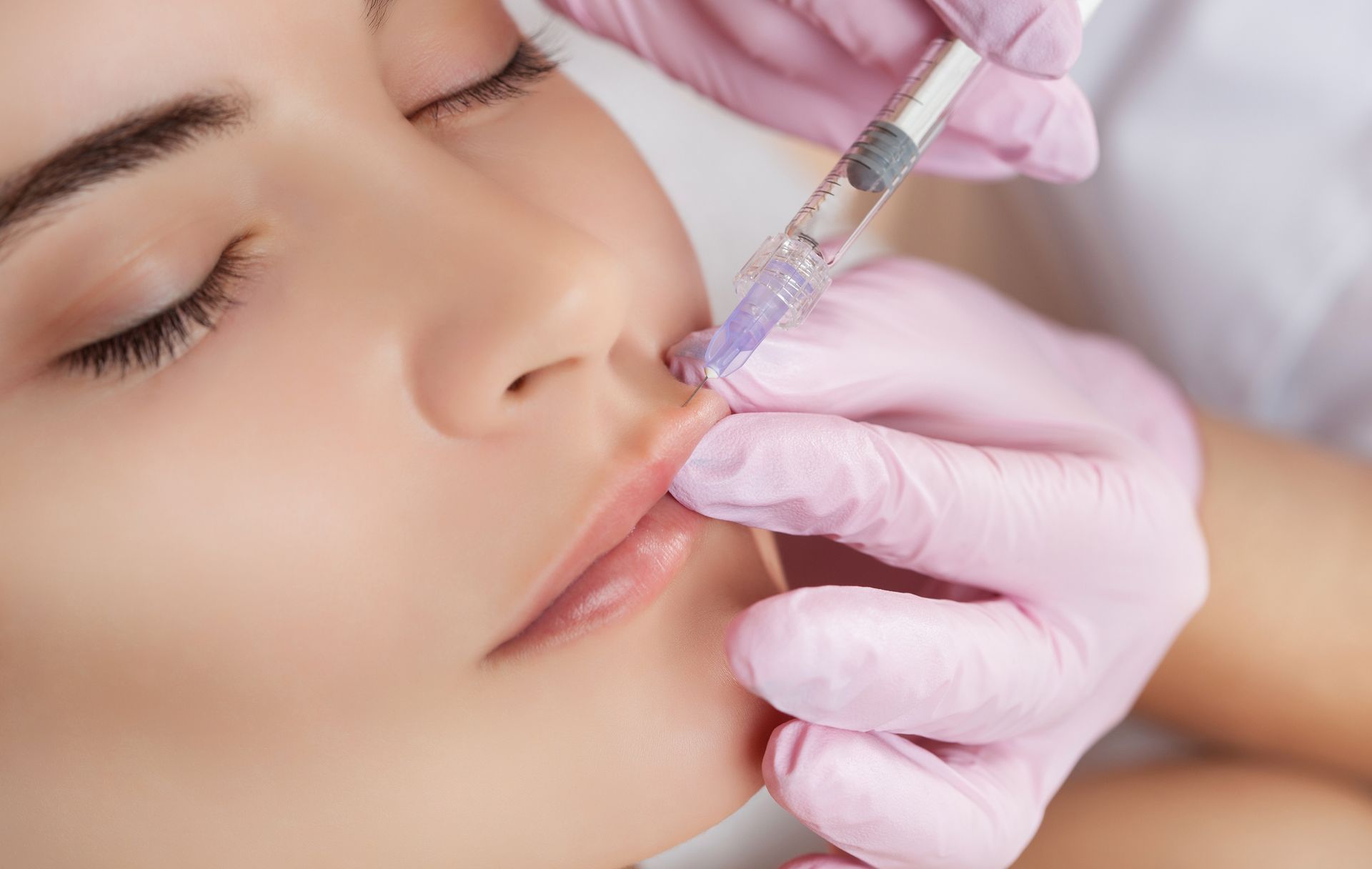 A woman is getting a botox injection in her lips. A woman is getting a botox injection in her lips.