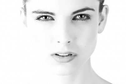It is a black and white photo of a woman 's face. It is a black and white photo of a woman 's face.