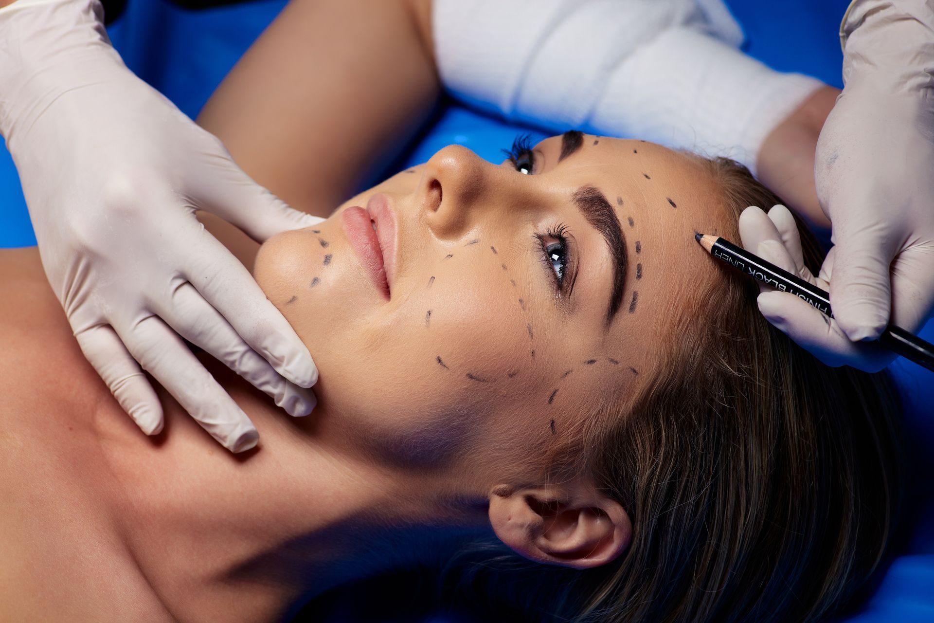 Cosmetic procedure on woman’s face with gloved hands applying treatment near her eyebrow