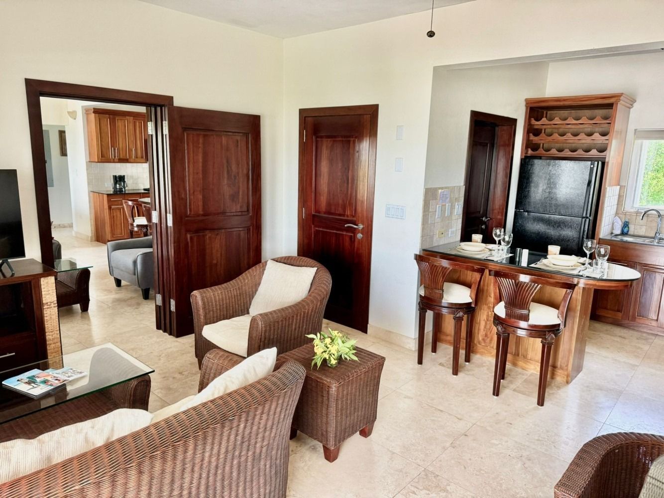 Living room with wicker furniture, bar, and doorway to a kitchen.