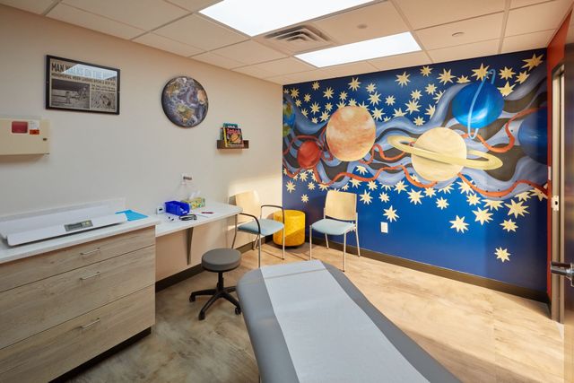 A pediatrician's office with a mural of the solar system on the wall.