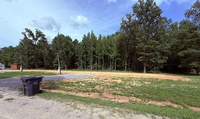 Mobile home positioned on a lot at Hickory Lane with a tidy yard and gravel driveway