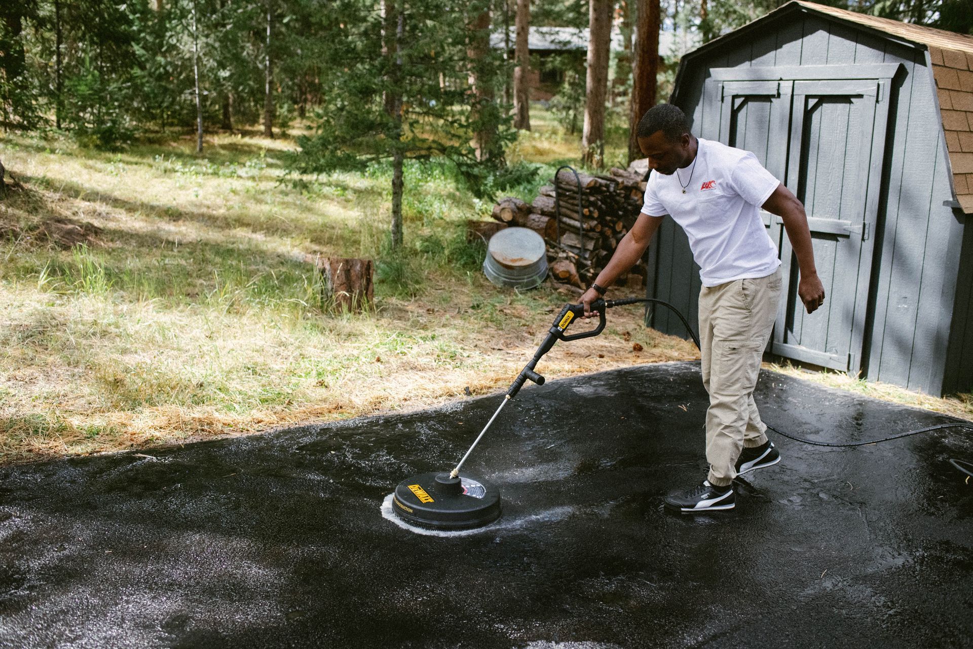 Worker using a floor scrubber to clean a dusty concrete surface indoors
