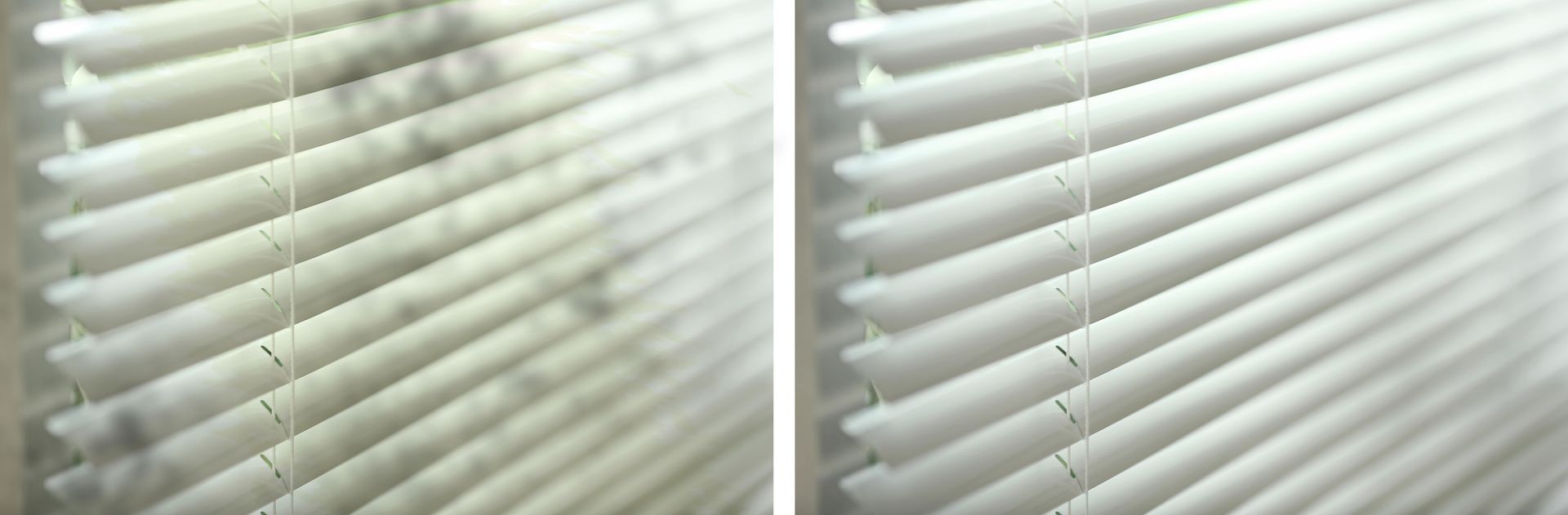 Close-up of white window blinds with light filtering through the slats